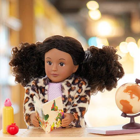 Mini doll reading a book.