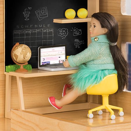 Mini doll sitting at a desk.