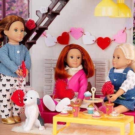 Three dolls making heart crafts.