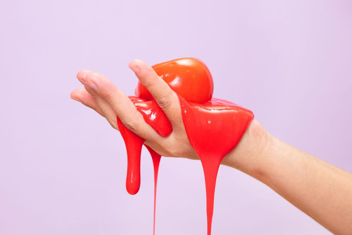 A hand holding orange slime.