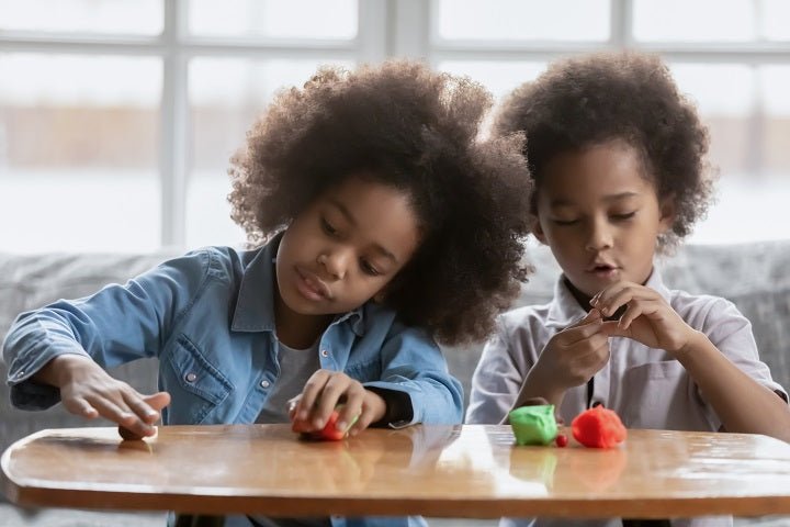 Two children create with playdough
