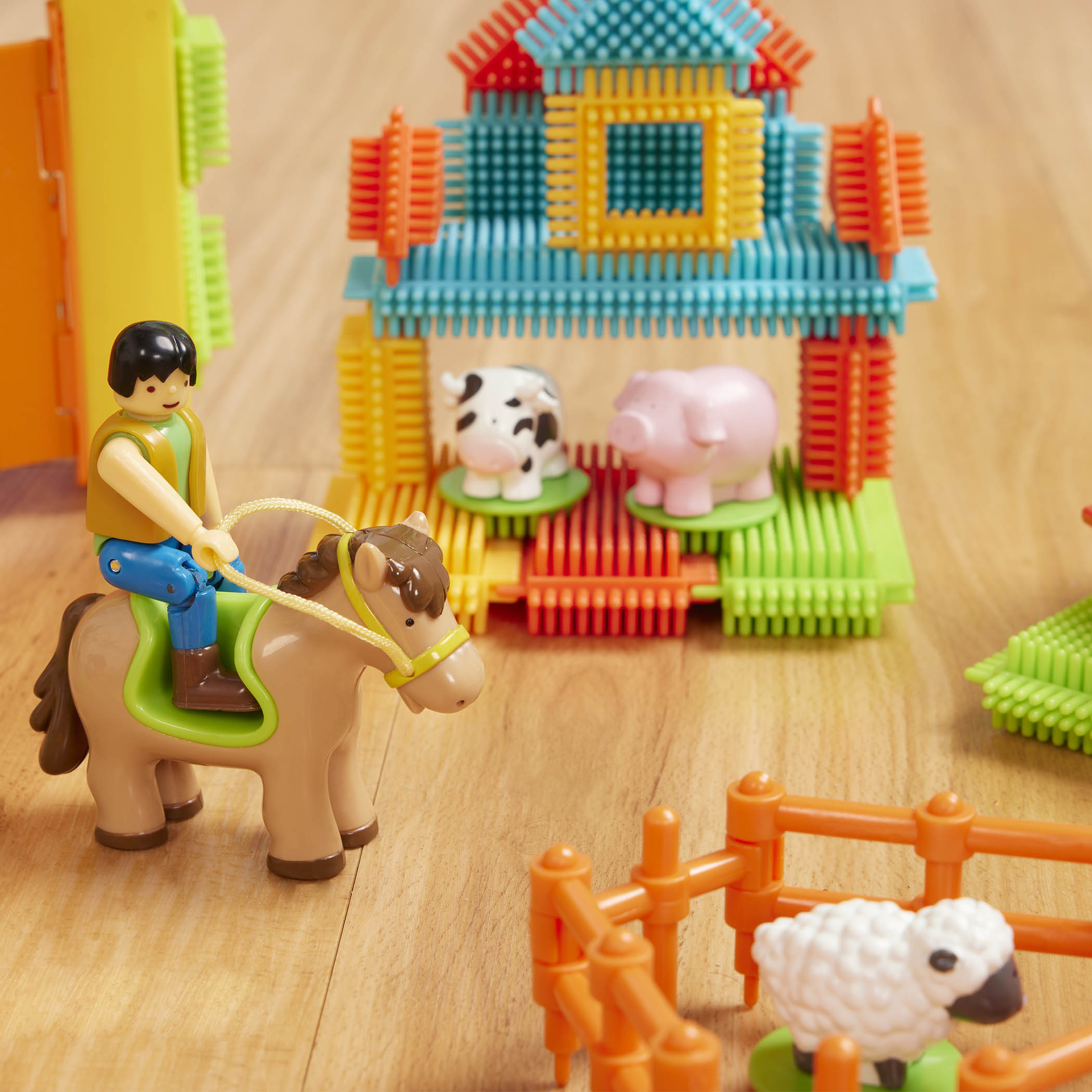 A 67-piece building block set with a farm theme, the set is laid out to show all the pieces, including animals, trees, and tractor.