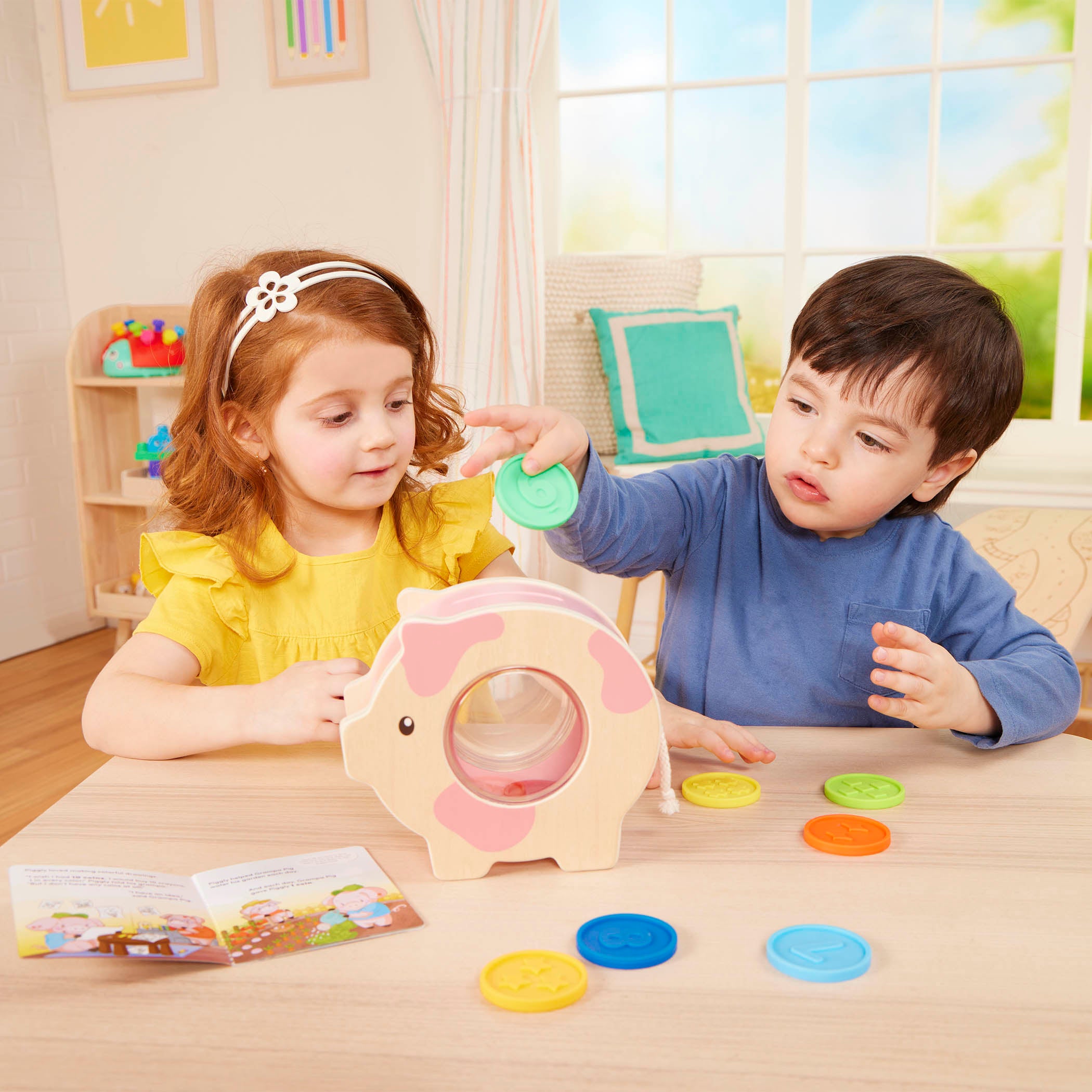 Piggy bank toy with colorful play coins and booklet.
