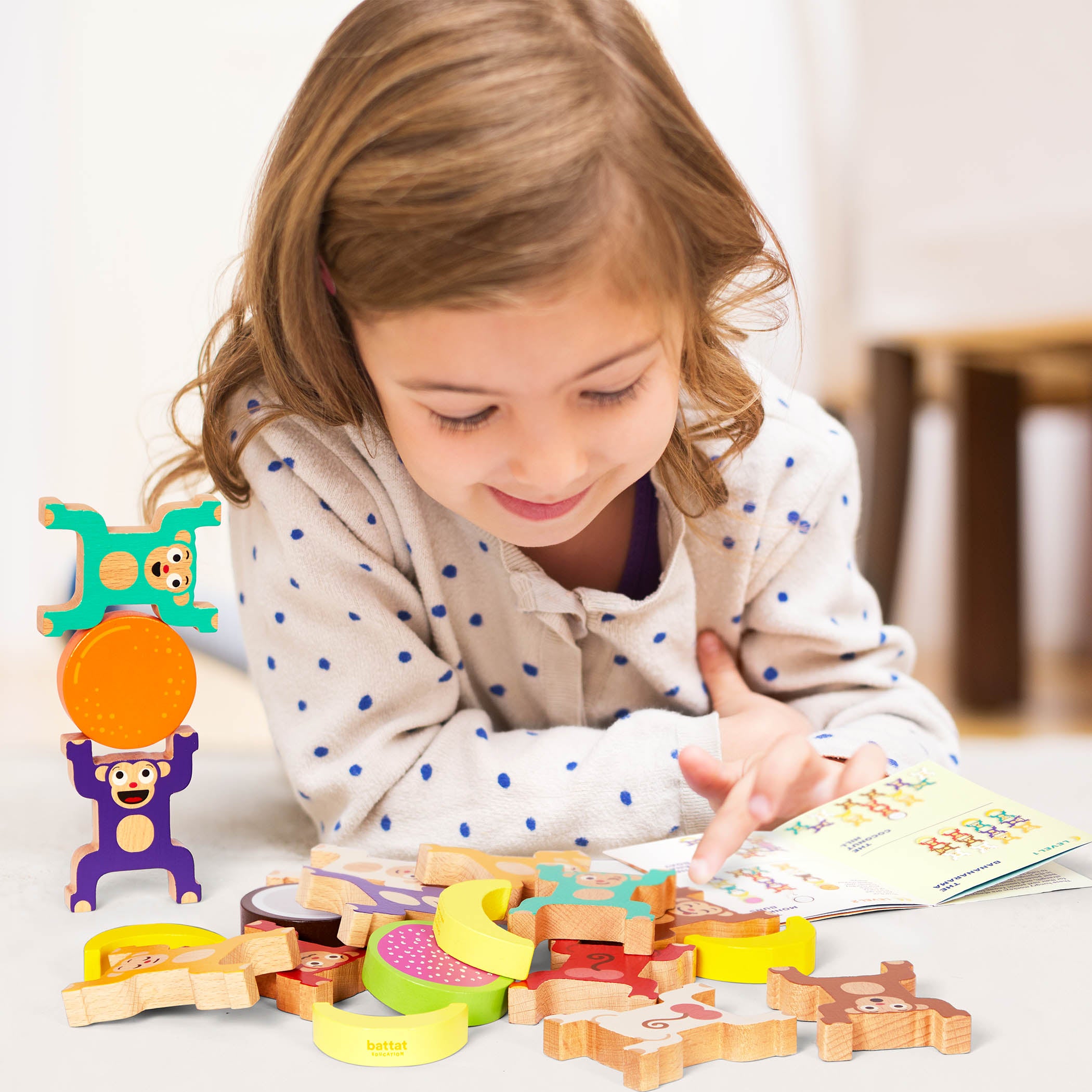 Colorful stacked monkey and fruit toys with a booklet.
