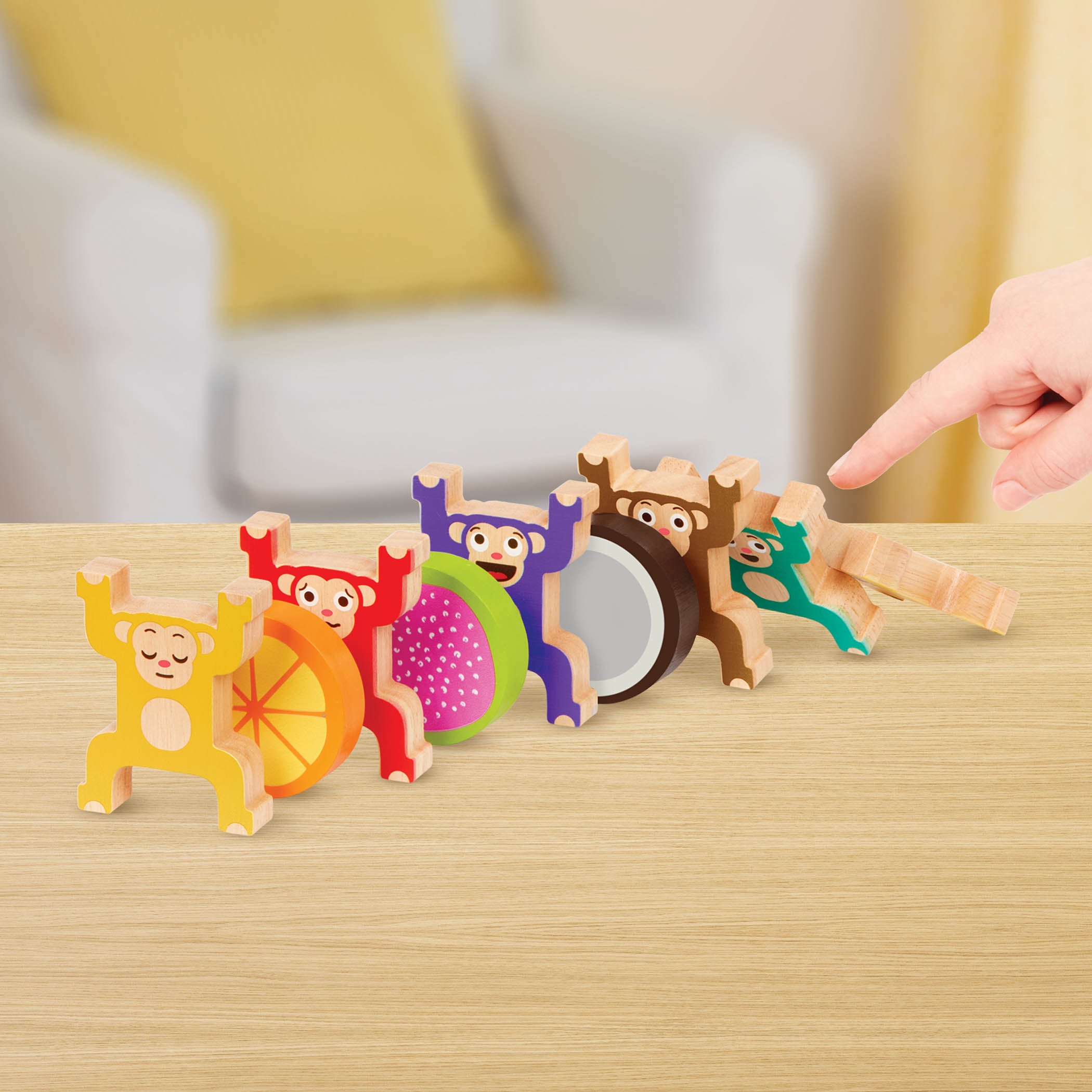 Colorful stacked monkey and fruit toys with a booklet.