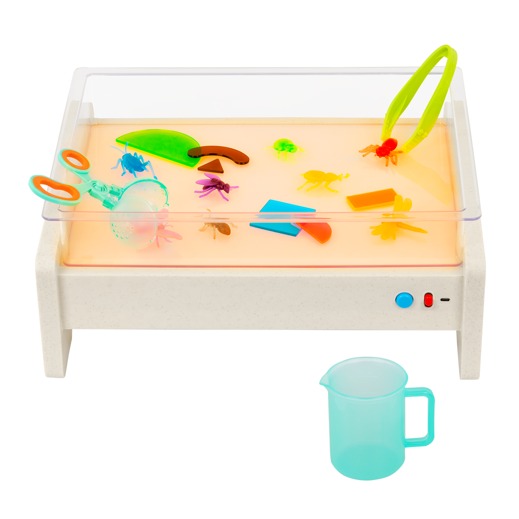 Light box playset with transculent shapes and bugs, tools, and a booklet.