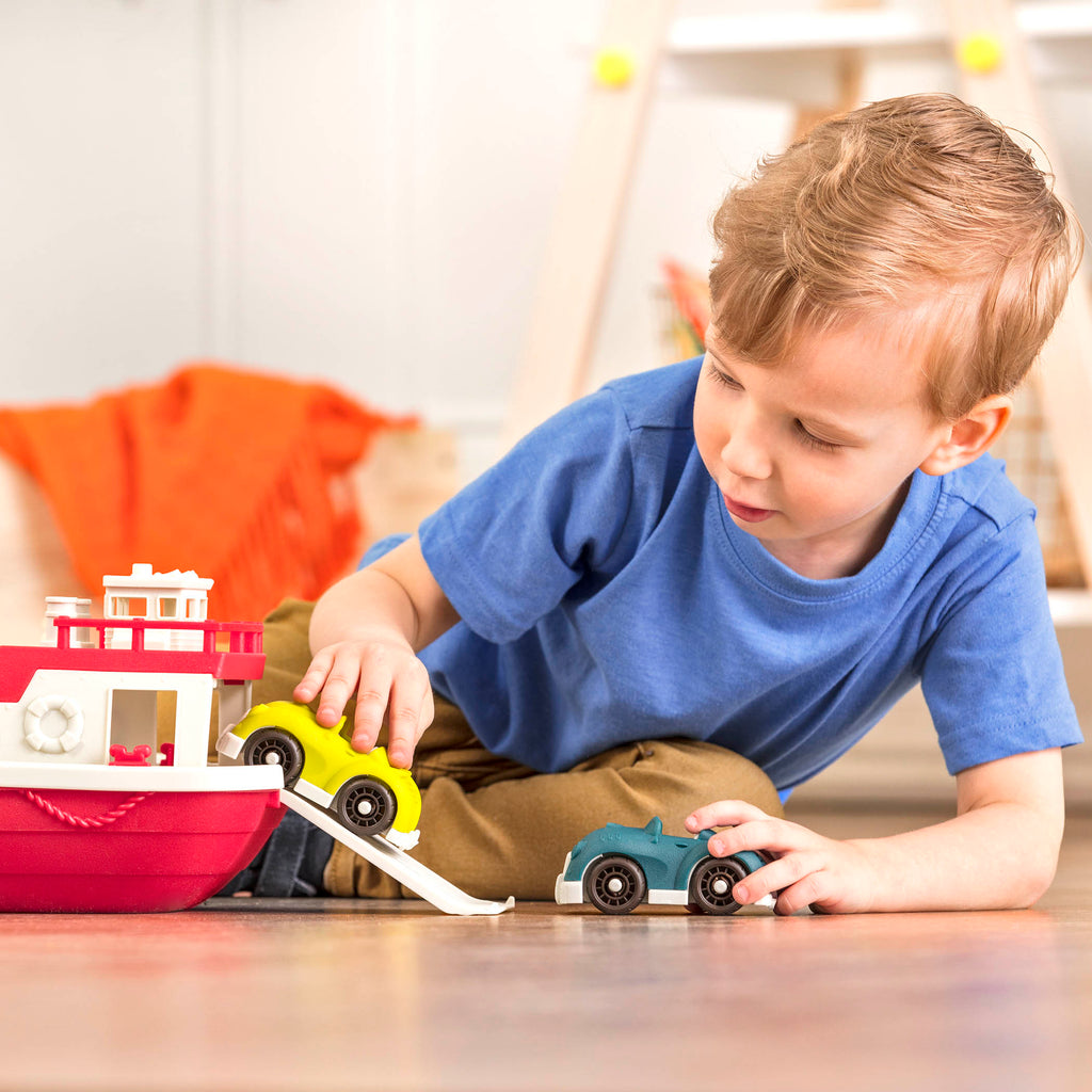 A ferry toy with the ramp down and 2 toy cars.