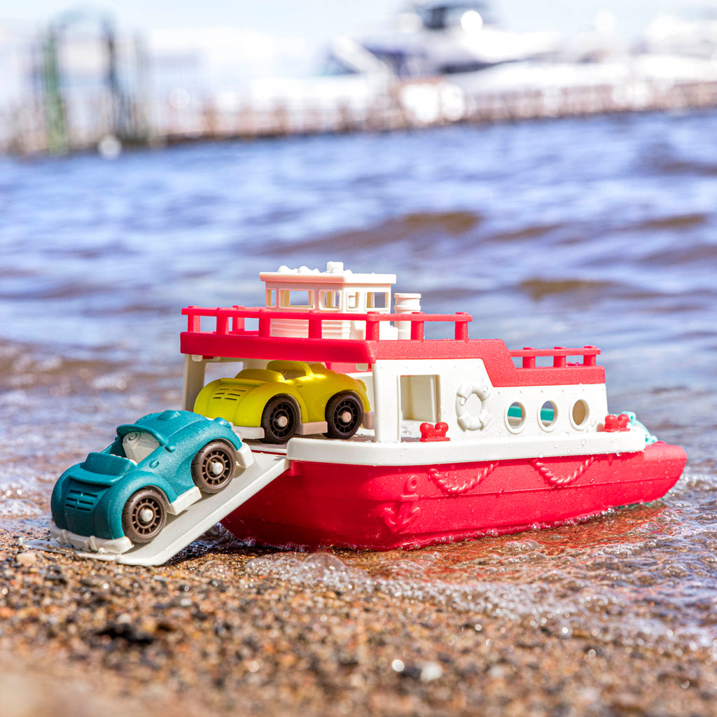 A ferry toy with the ramp down and 2 toy cars.