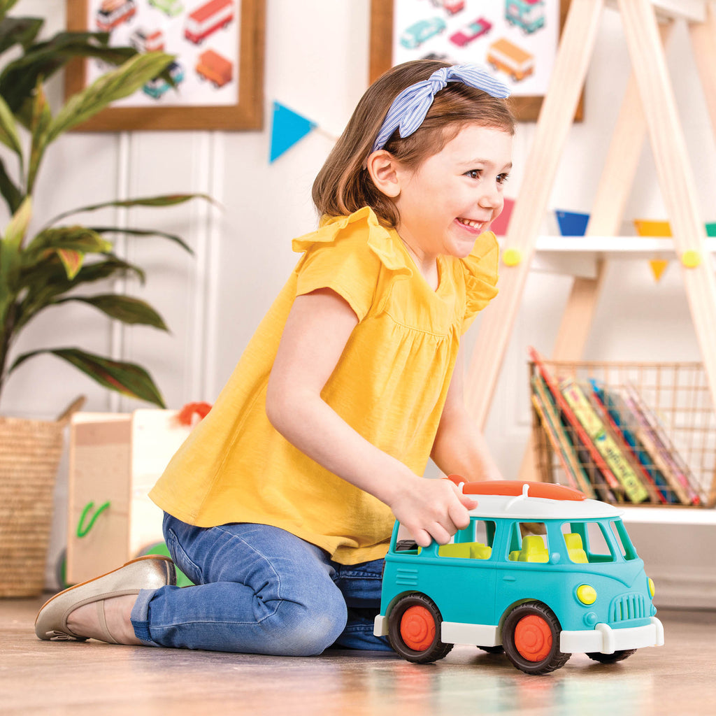 A blue camper van with a green interior and an orange surfboard on top.