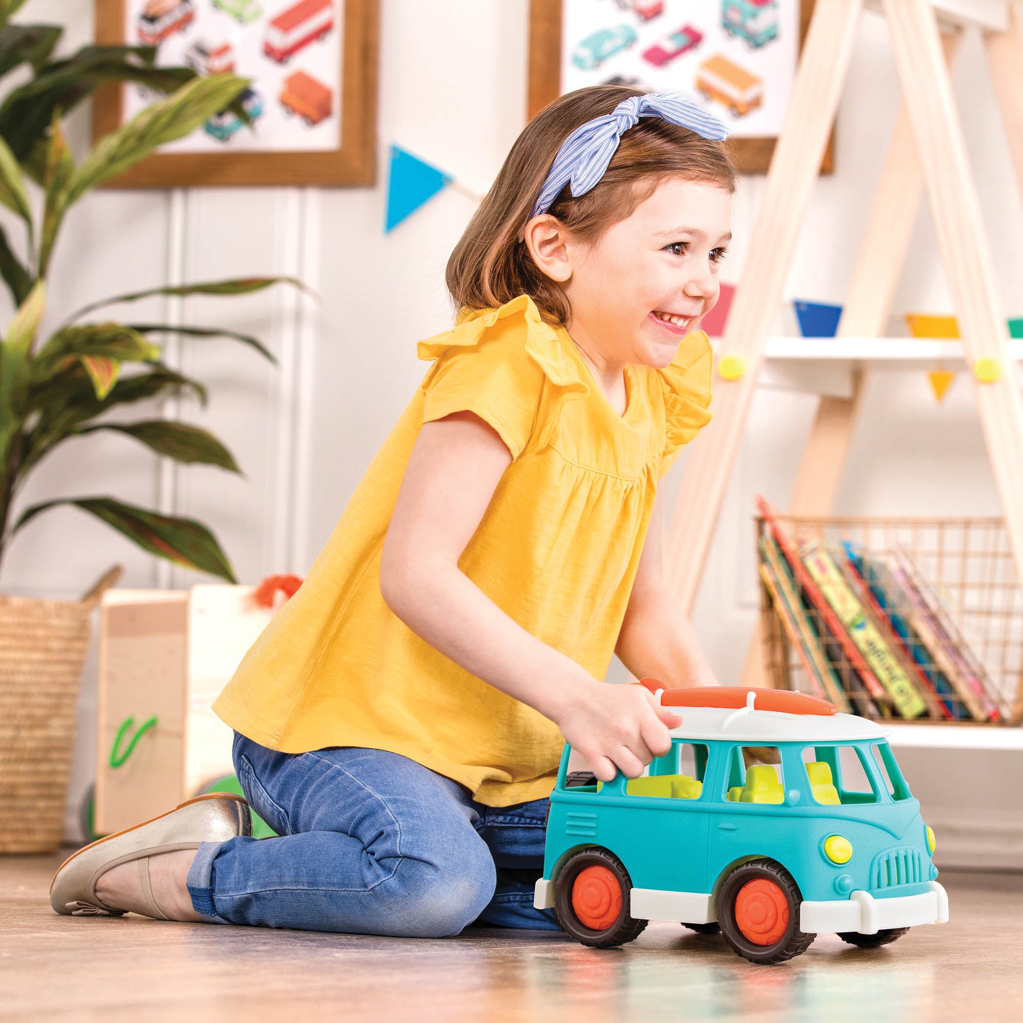 A blue camper van with a green interior and an orange surfboard on top.