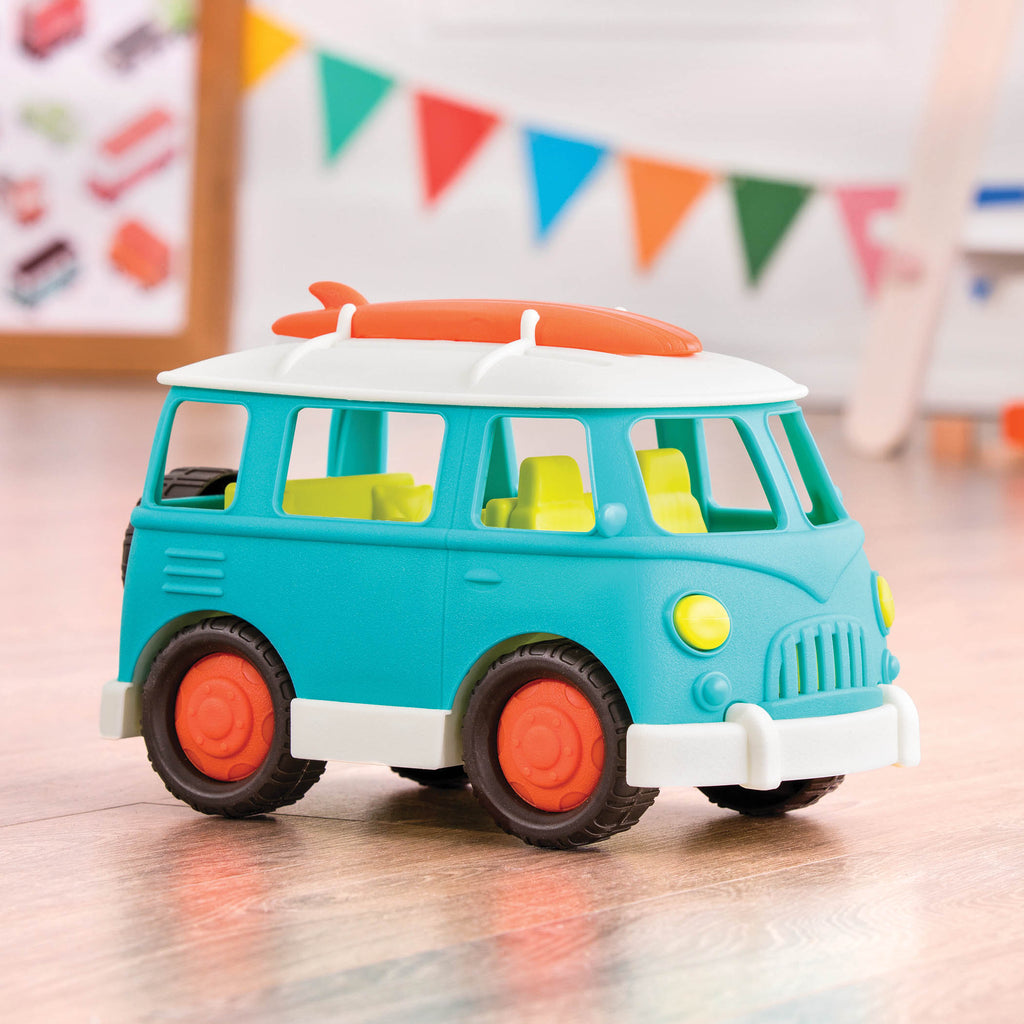 A blue camper van with a green interior and an orange surfboard on top.