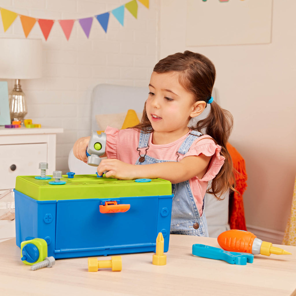 A blue and green toy tool box surrounded by toy tools.