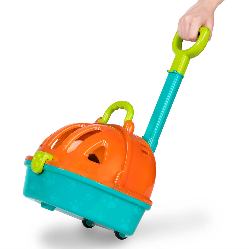 A toy pet carrier with a plush puppy inside and vet tools surrounding it.