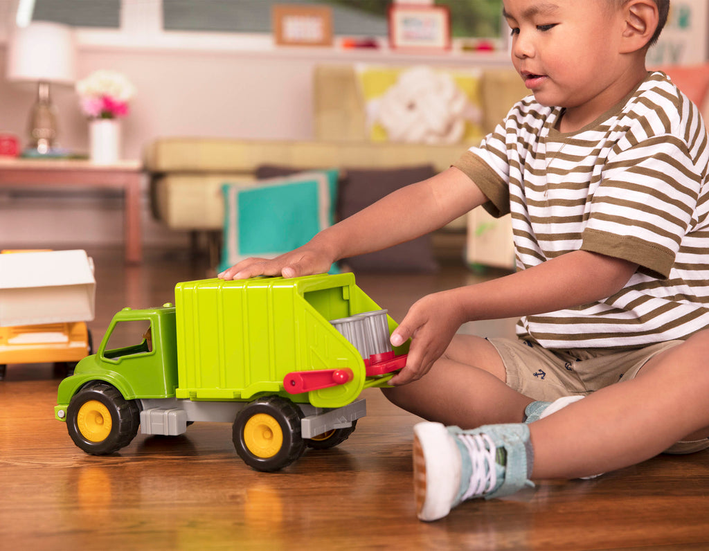 A green toy garbage truck for kids with a little driver figurine in the front seat.