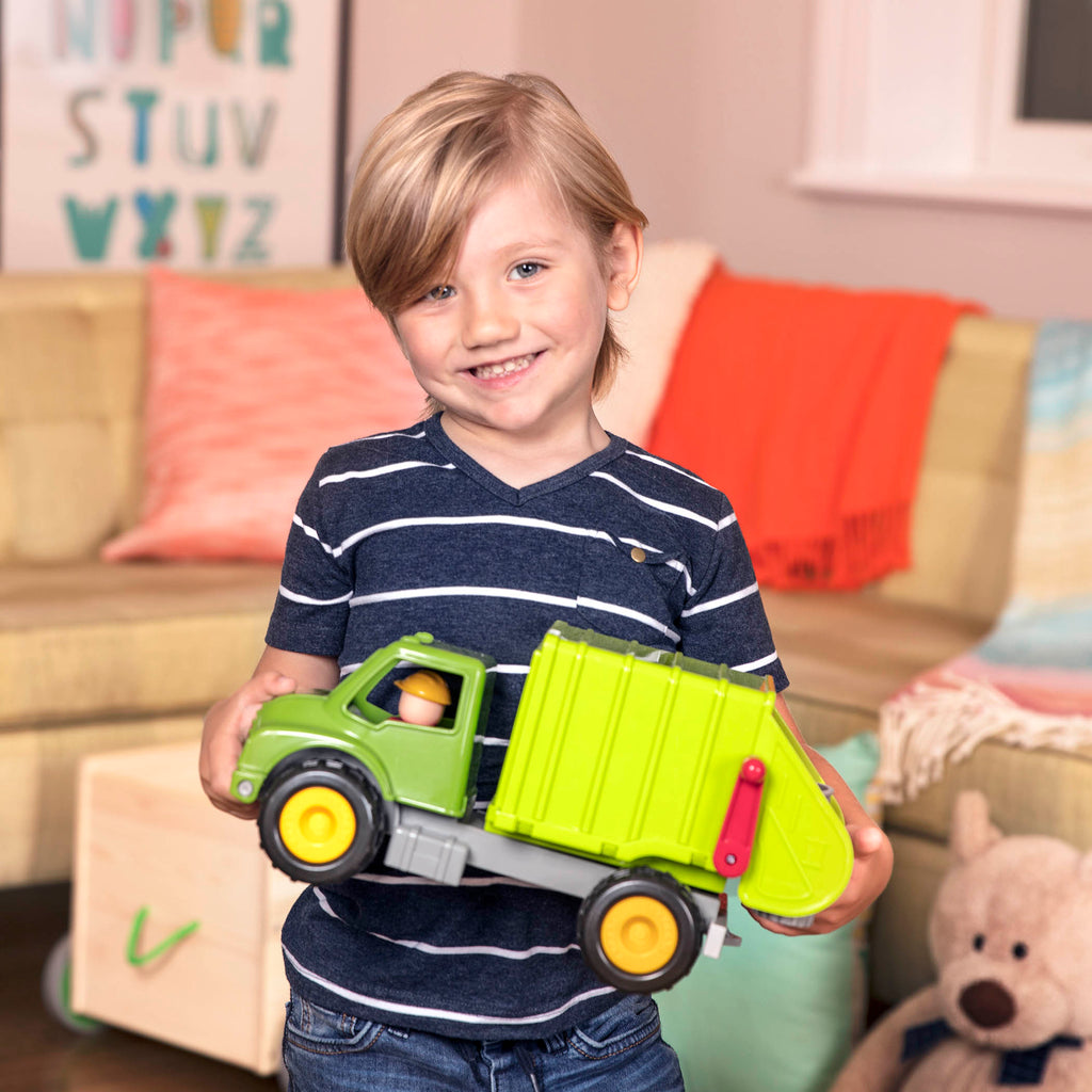 A green toy garbage truck for kids with a little driver figurine in the front seat.