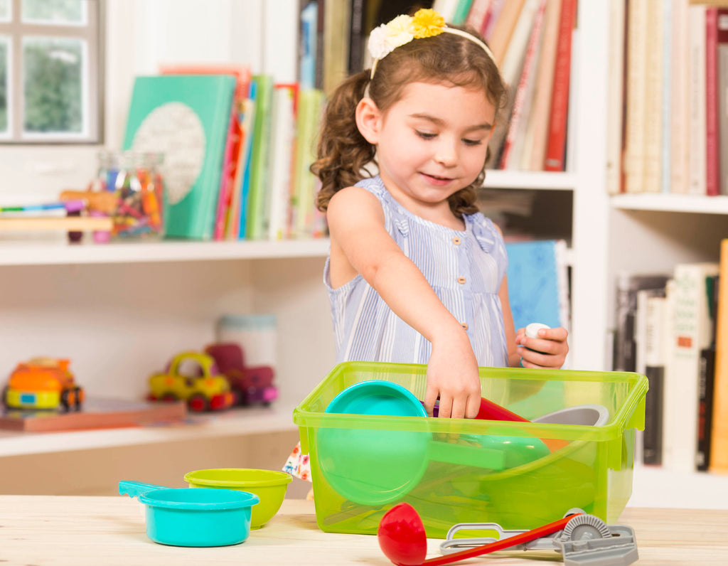 A toy cooking set with a huge variety of different tools in a green bin.