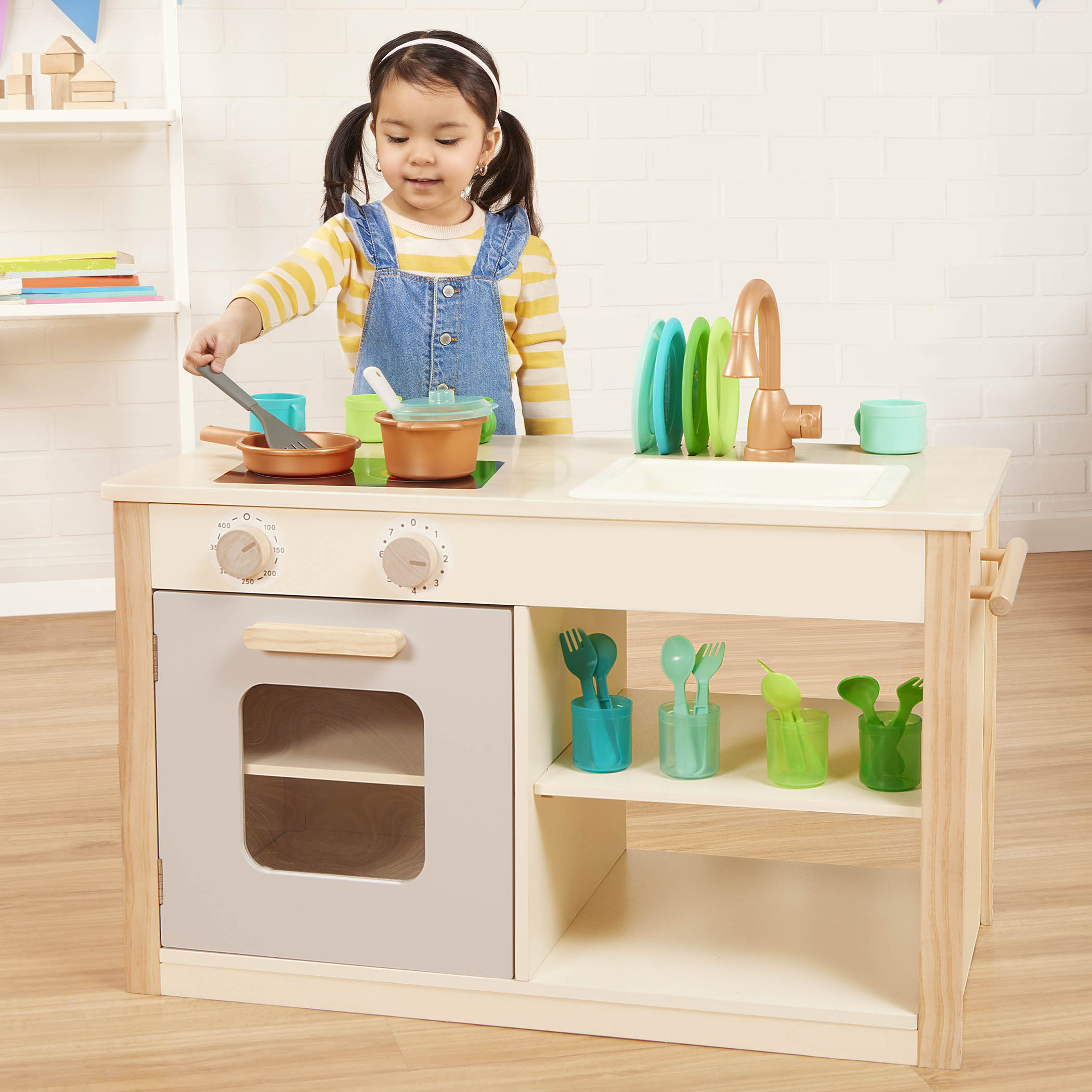 Wooden toy kitchen with colorful accessories.