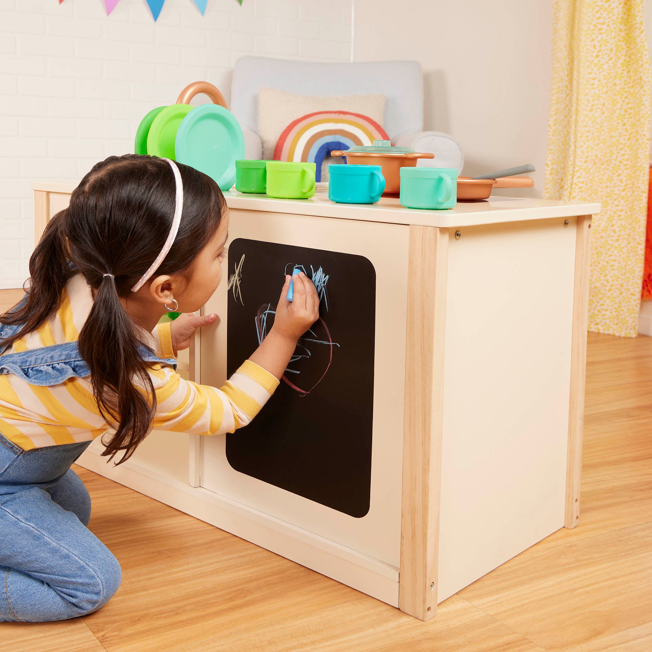 Wooden toy kitchen with colorful accessories.
