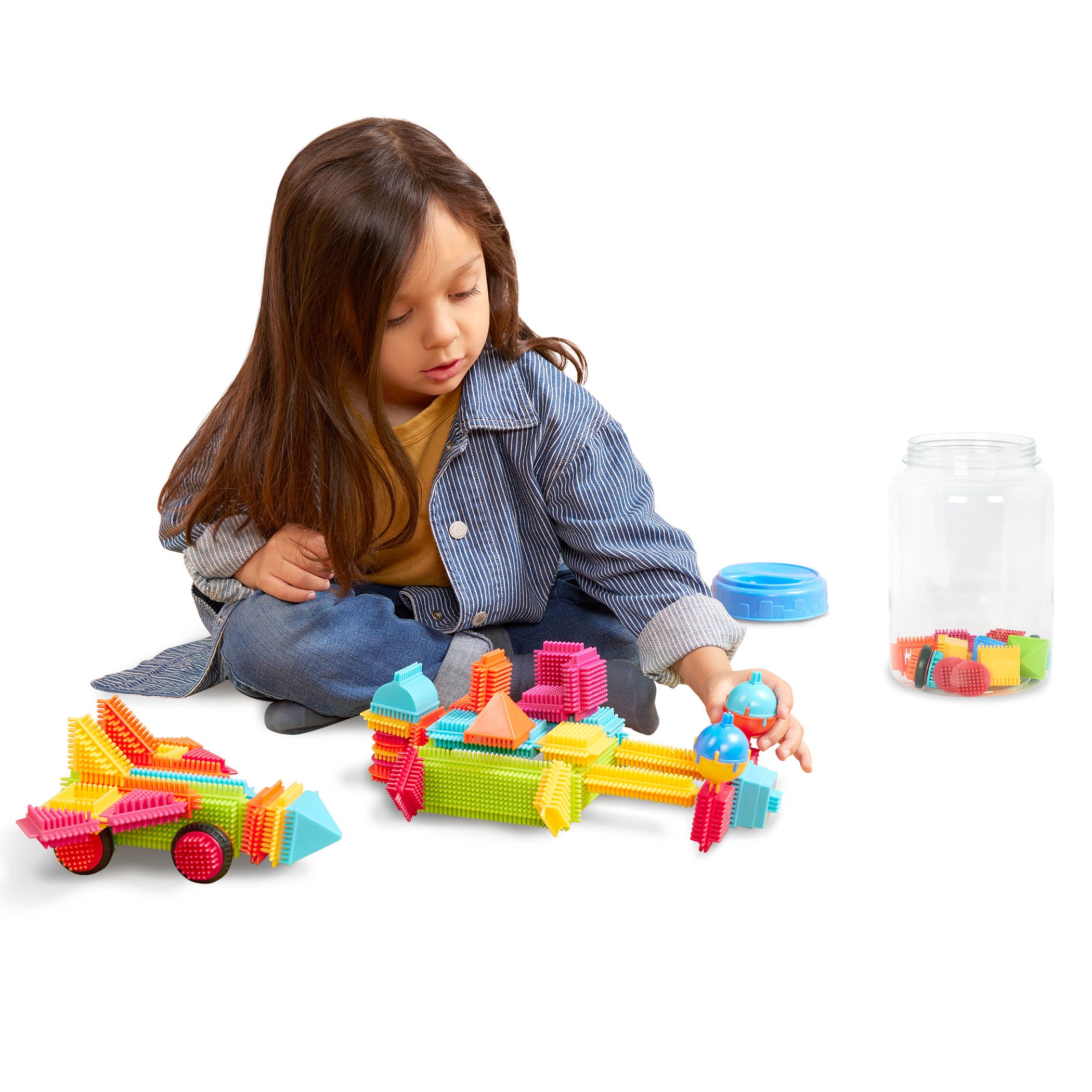 A colorful array of Bristle Blocks laid out so we can see all the pieces and the big reusable storage container.