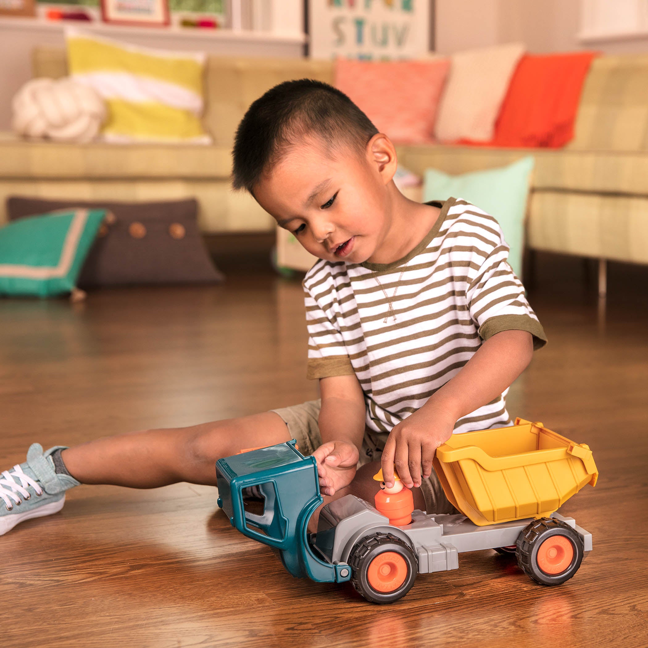 A toy dump truck with a little driver for kids and toddlers.