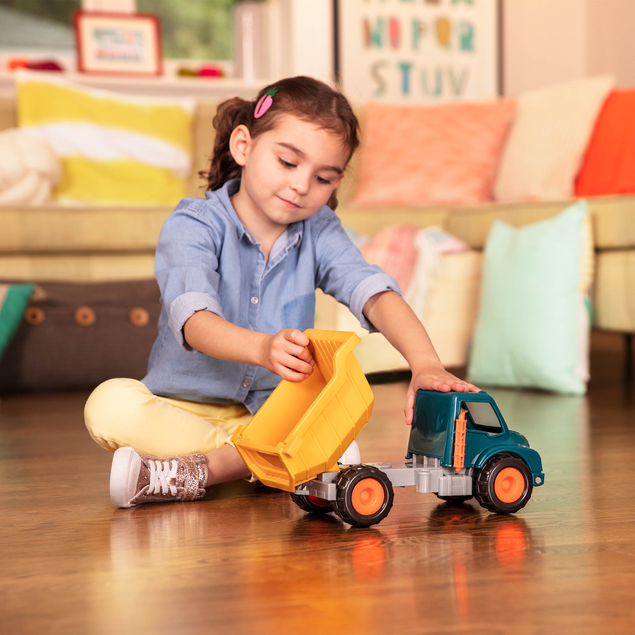 A toy dump truck with a little driver for kids and toddlers.