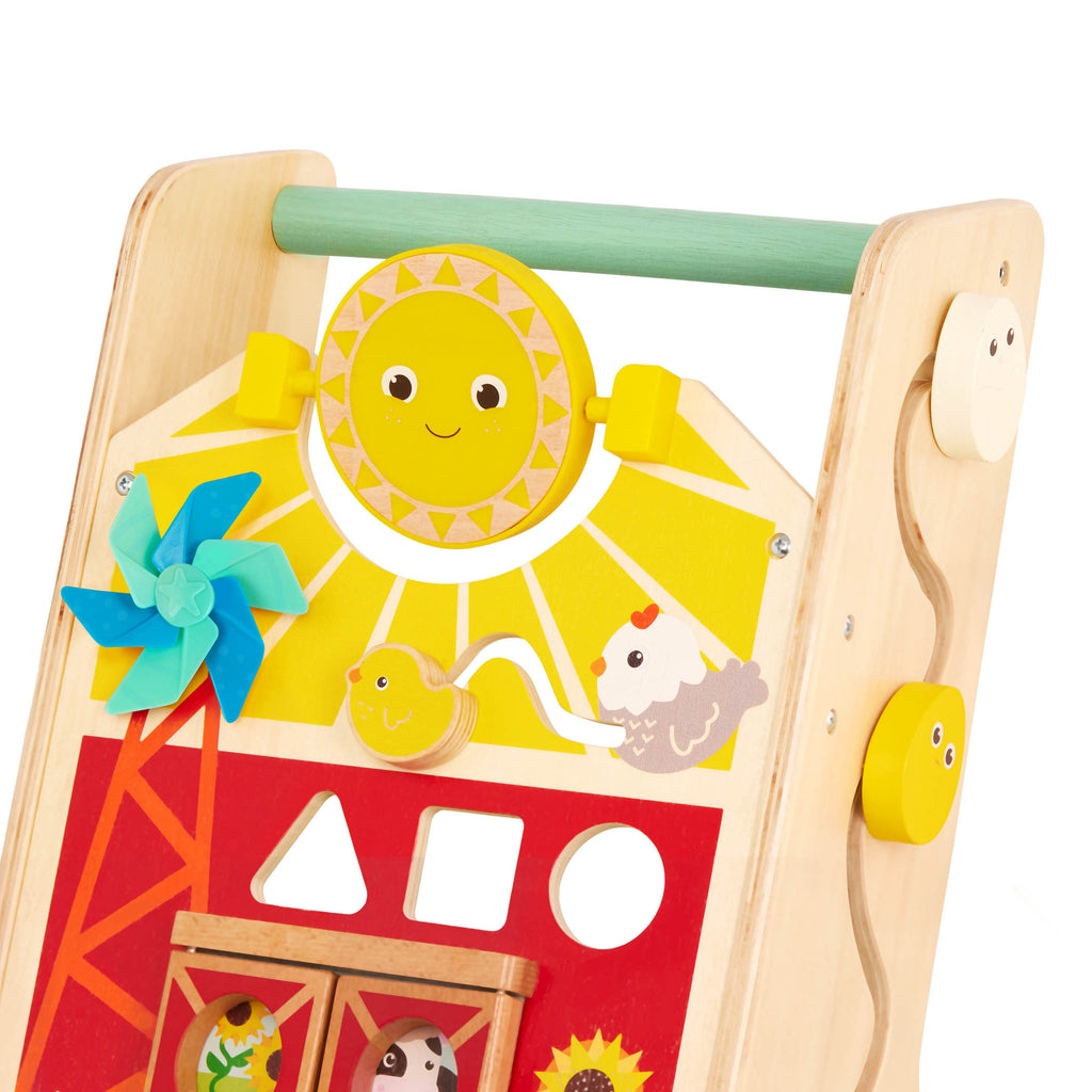 A baby walker toy with blocks and colorful handkerchiefs.