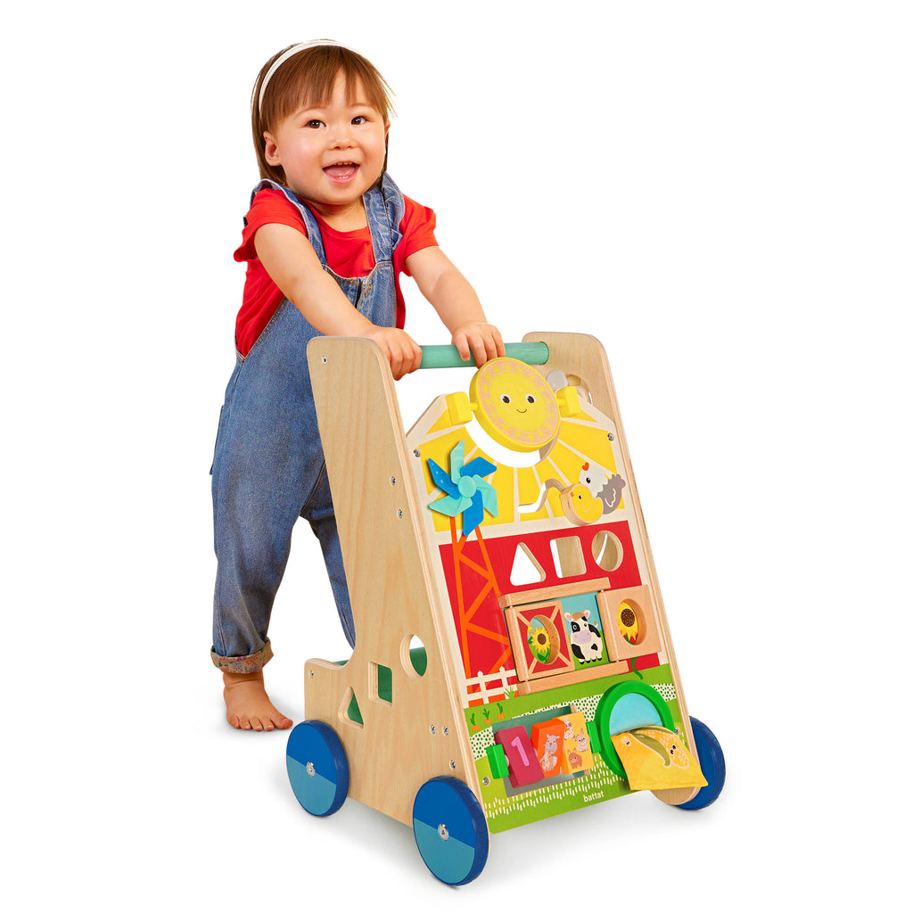 A baby walker toy with blocks and colorful handkerchiefs.