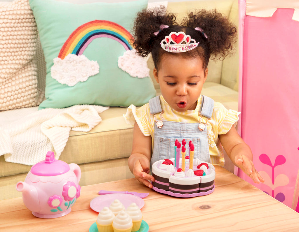 2 slices of pretend birthday cake with candles and utensils.