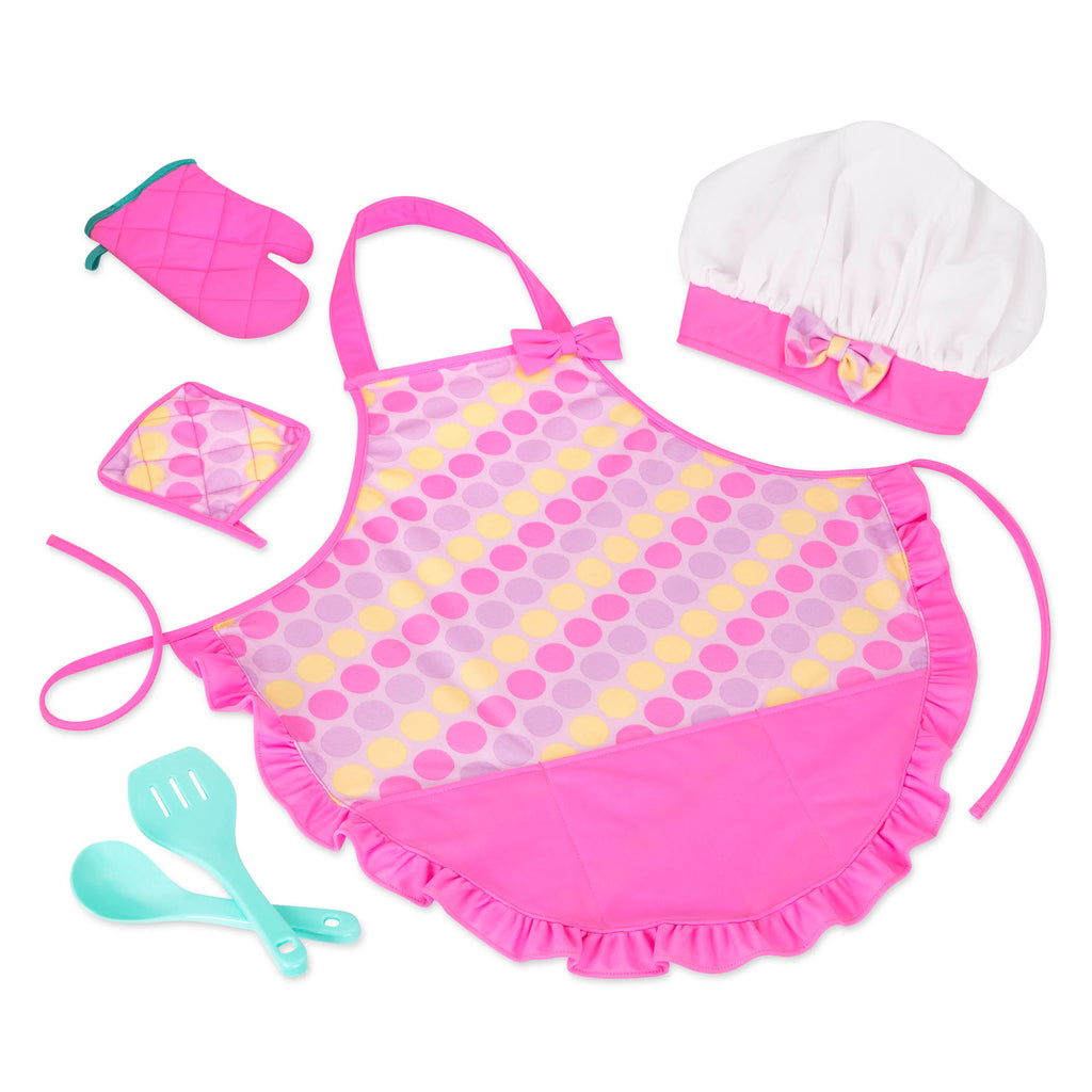 A pink apron set for kids with a chef's hat, oven mitt, and more.IThe Smart Cookie Chef's Apron in a realistc setting, there is an apron, chef's hat, oven mitt, cooking utensils and pot holder.