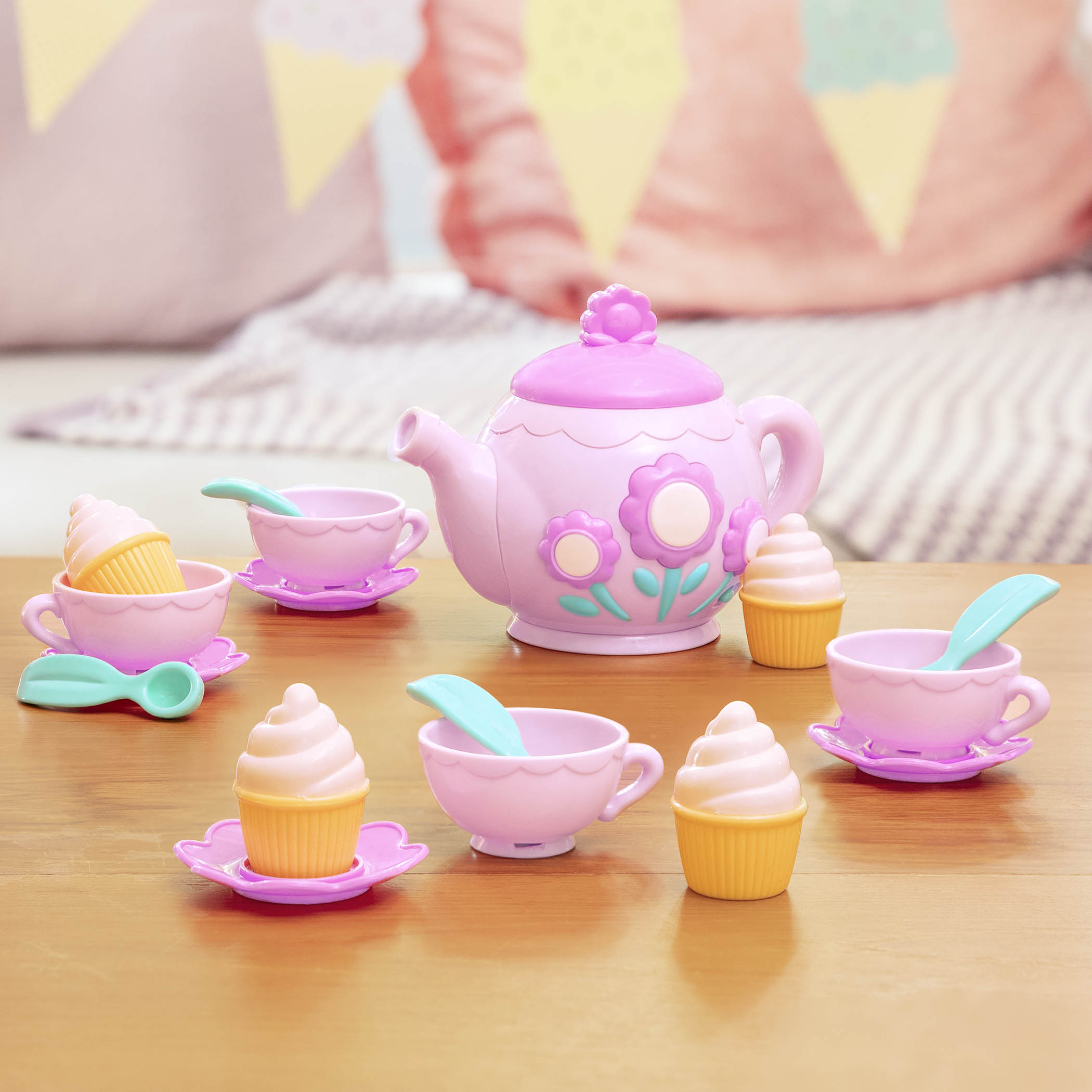 A toy tea set with toy cupcakes.