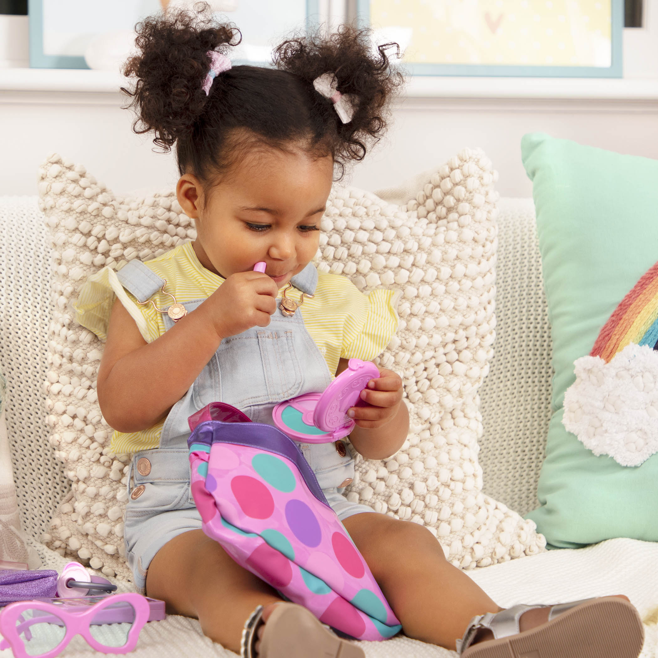 A pink and purple purse set for toddlers and kids, it comes with accessories like a compact mirror, pretend lipstick, coin purse, and more.