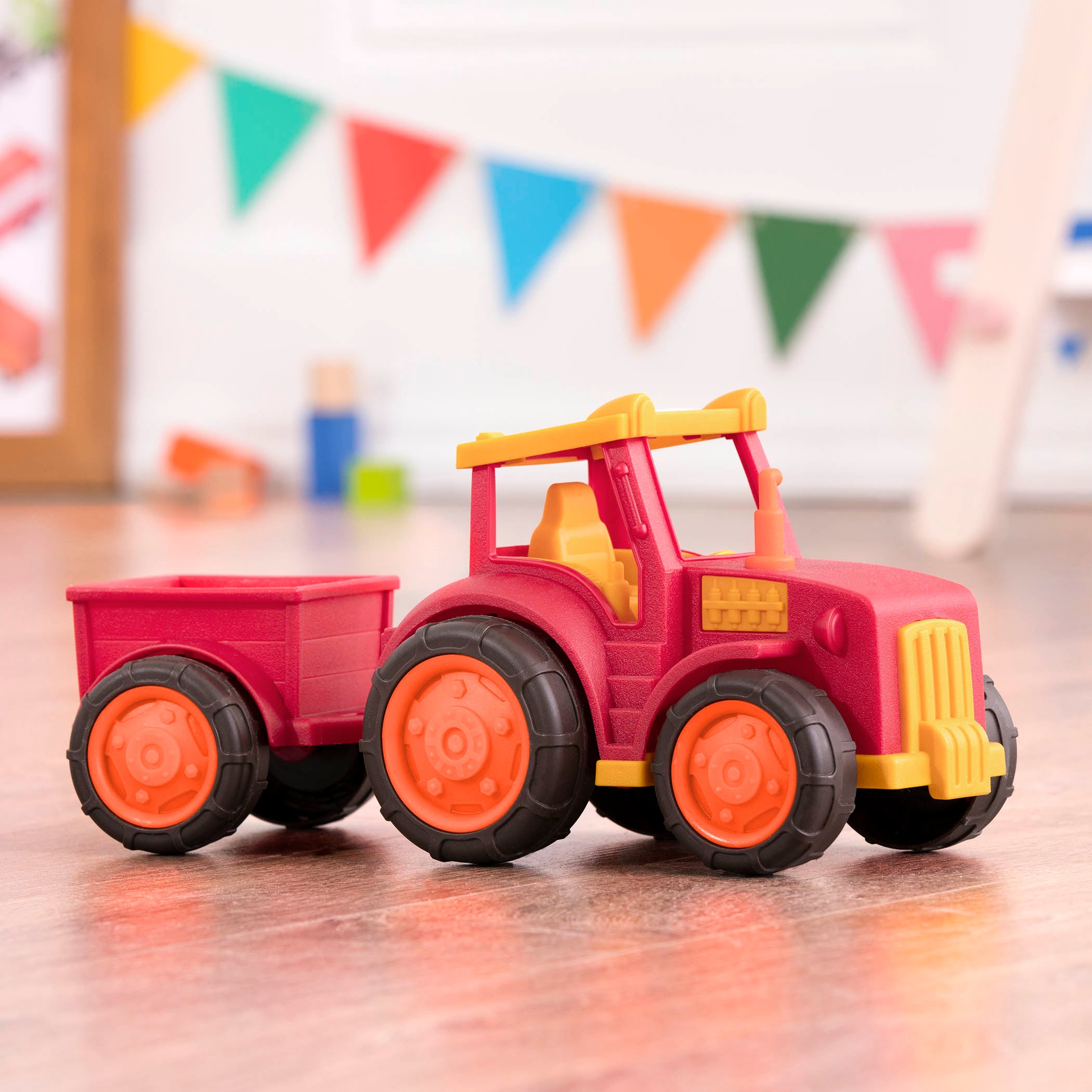 A red tractor toy with a detachable trailer.