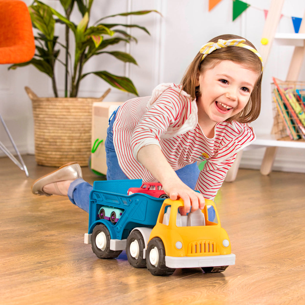 A yellow and blue car carrier truck with 2 toy cars aboard.