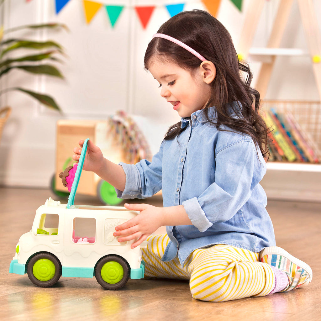 A toy ice cream truck with a pretend scoop of ice cream on the roof.