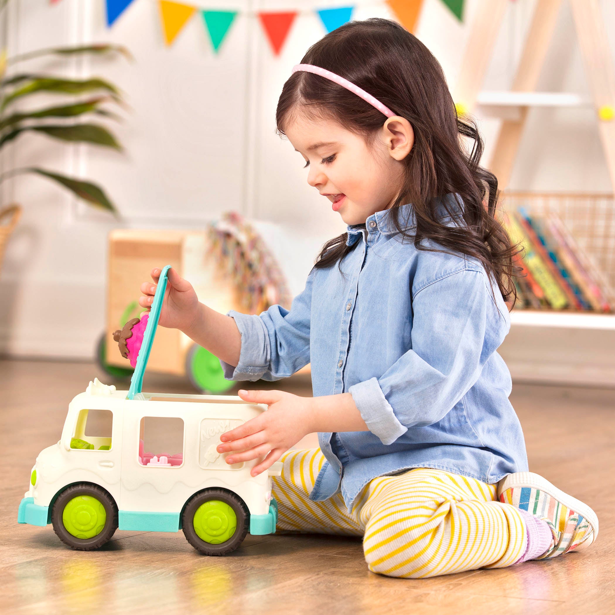 A toy ice cream truck with a pretend scoop of ice cream on the roof.