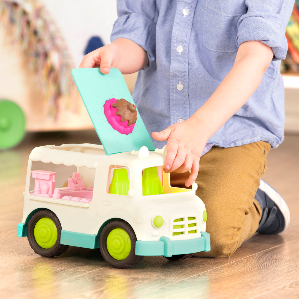 A toy ice cream truck with a pretend scoop of ice cream on the roof.
