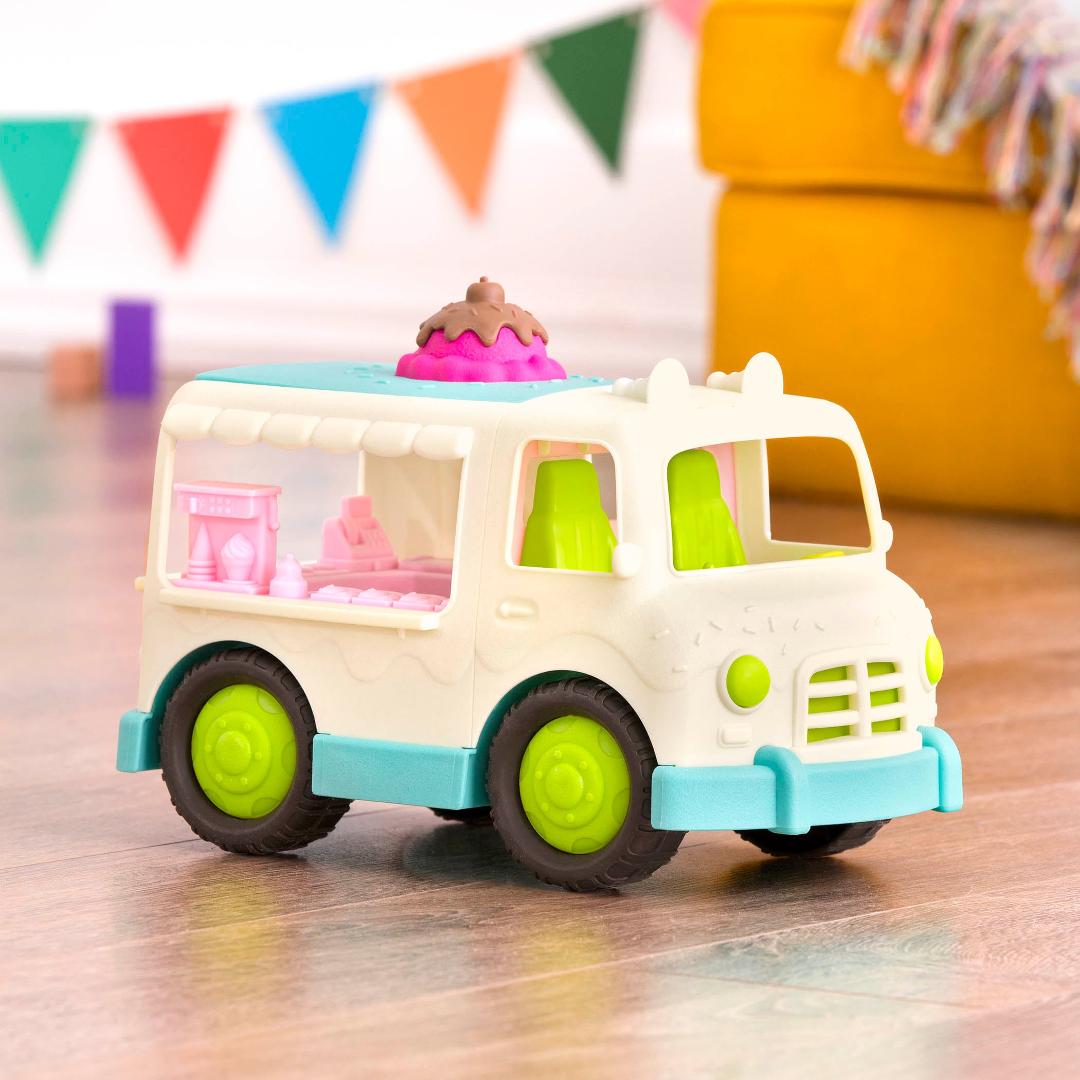 A toy ice cream truck with a pretend scoop of ice cream on the roof.