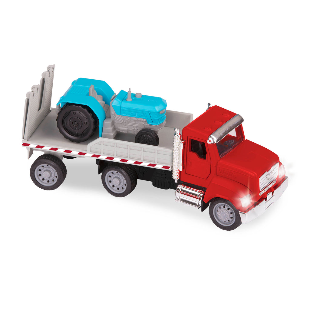 Red toy flatbed truck carrying blue tractor